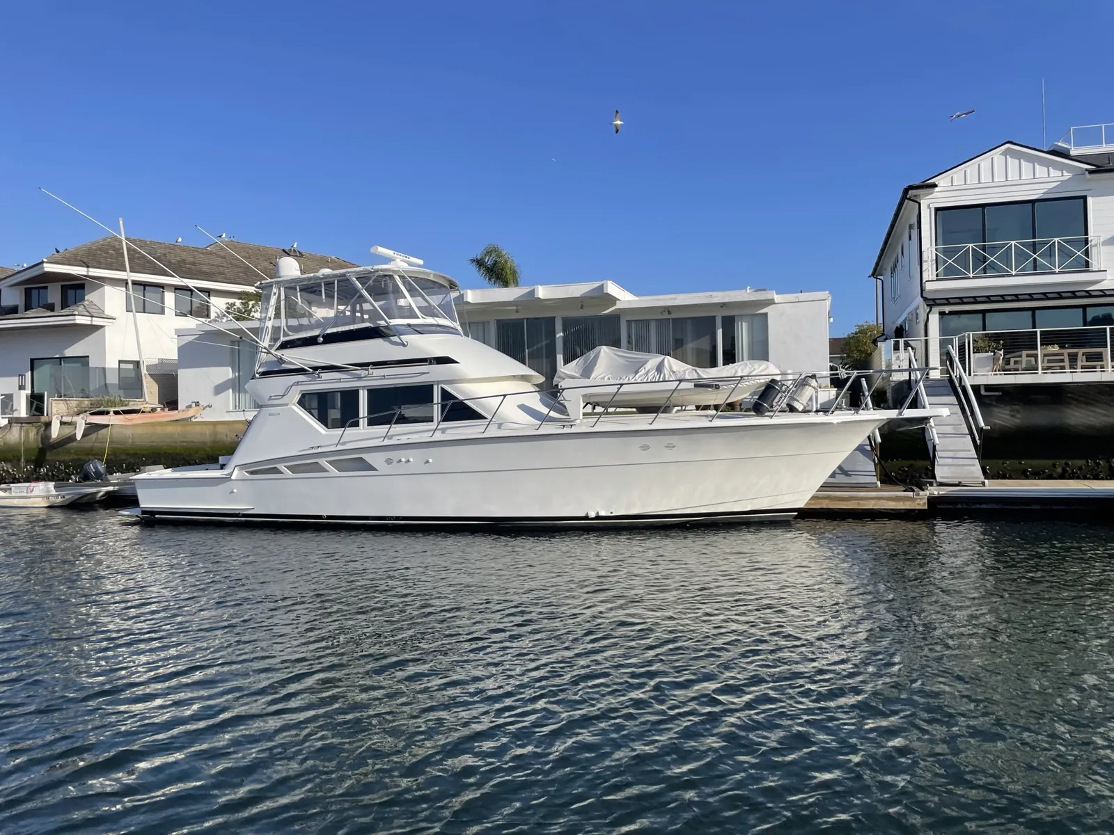 Merityme III, a white sportfisher, at her slip in Huntington Harbour on a clear day